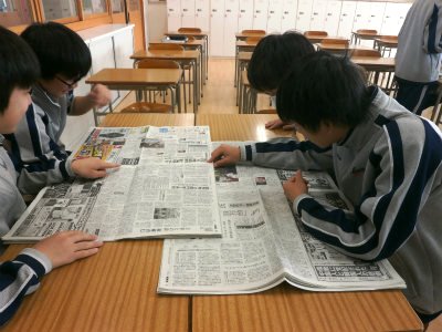 新聞を読み、討論する生徒